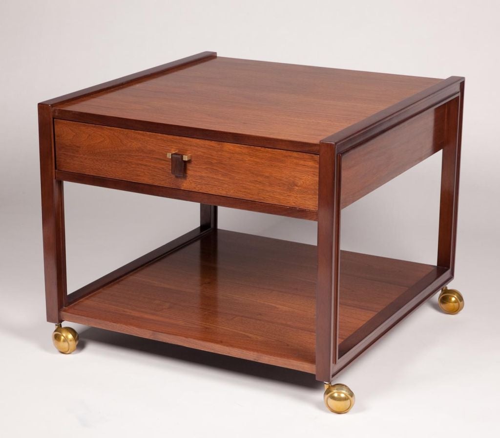 Pair of modernist two-tone Walnut side tables with one drawer with a rosewood pull on brass casters. Designed by Edward Wormley for Dunbar. This item is located at our off site storage facility, please call to schedule a viewing. Sale $4800/pair