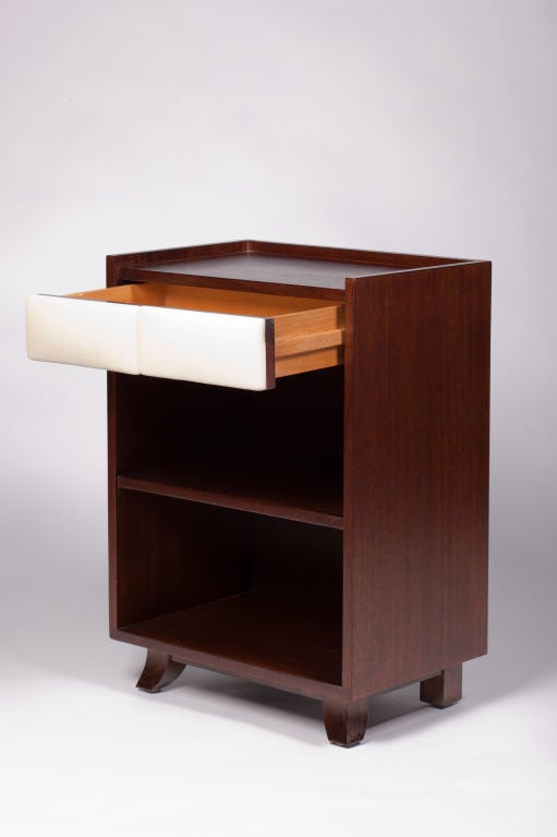 Exceptional pair of mahogany nightstands with cream padded leather drawer fronts and one shelf. Designed by Gilbert Rohde for Herman Miller.
