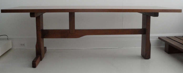 Dining table designed by Giovanni Michelluci. Asymmetrical trestle base in Italian light solid walnut, walnut veneer top. Designed for a small company: DELECTA with other few examples in 1981.Base is stamped: DELECTA, the rectangle top is signed: