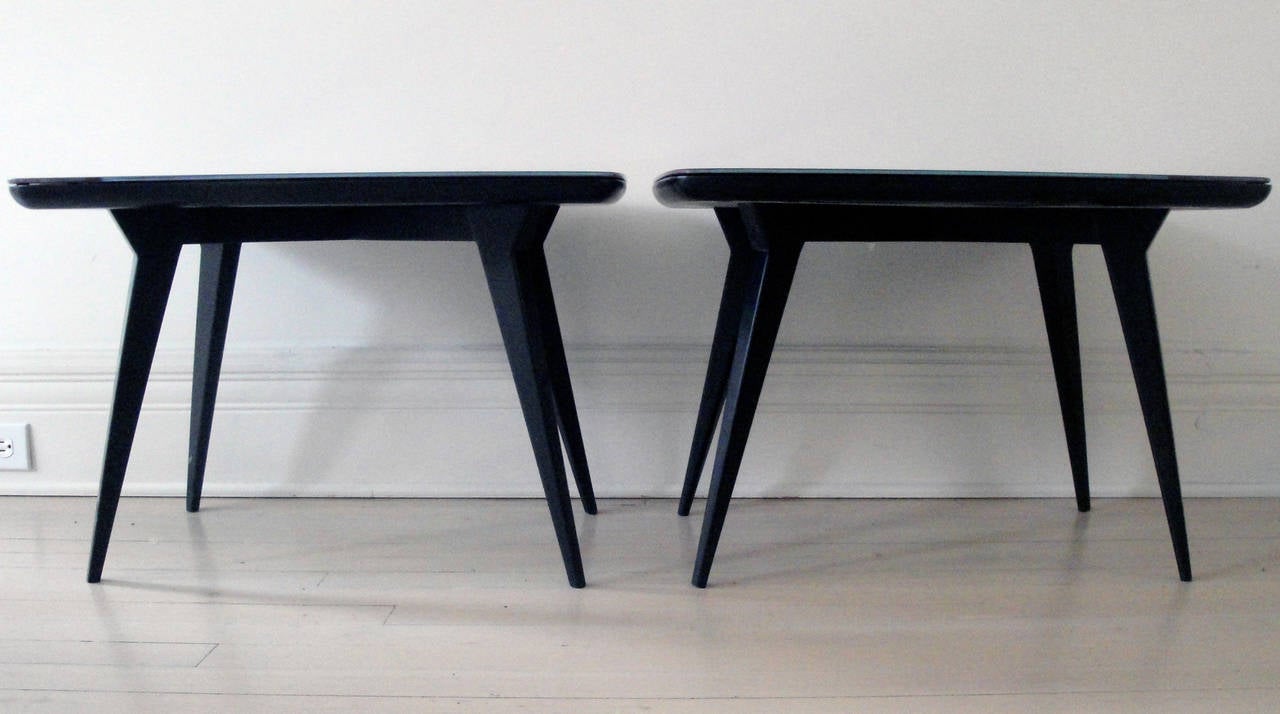 Two back lacquered Ponti style small tables with aubergine glass tops.
Rectangular tops with round edges.