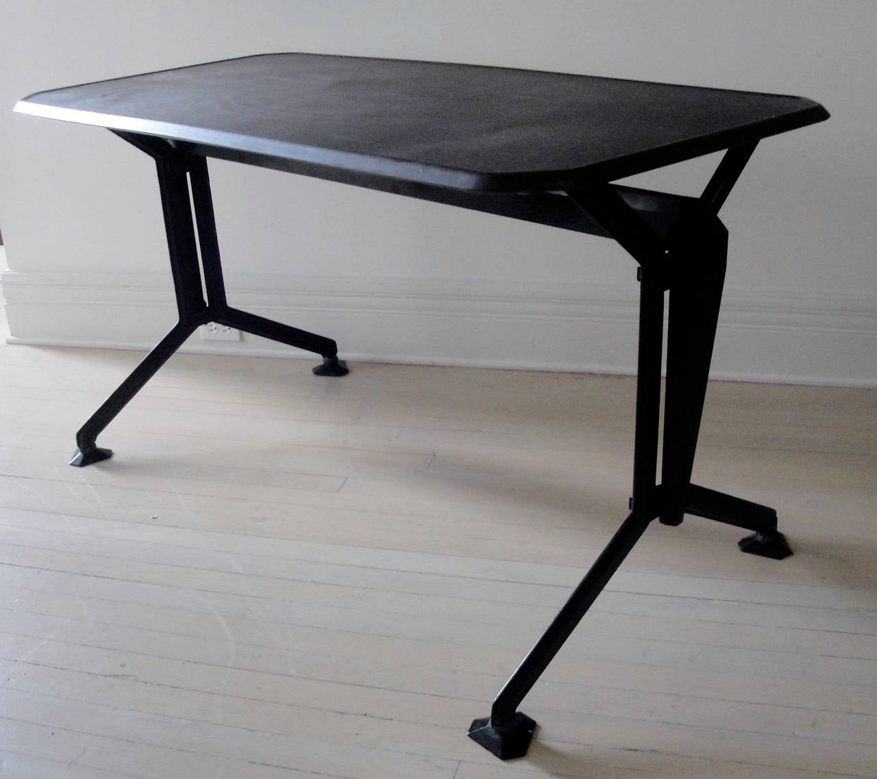 An Olivetti table with metal interlinked base and a bakelite top.