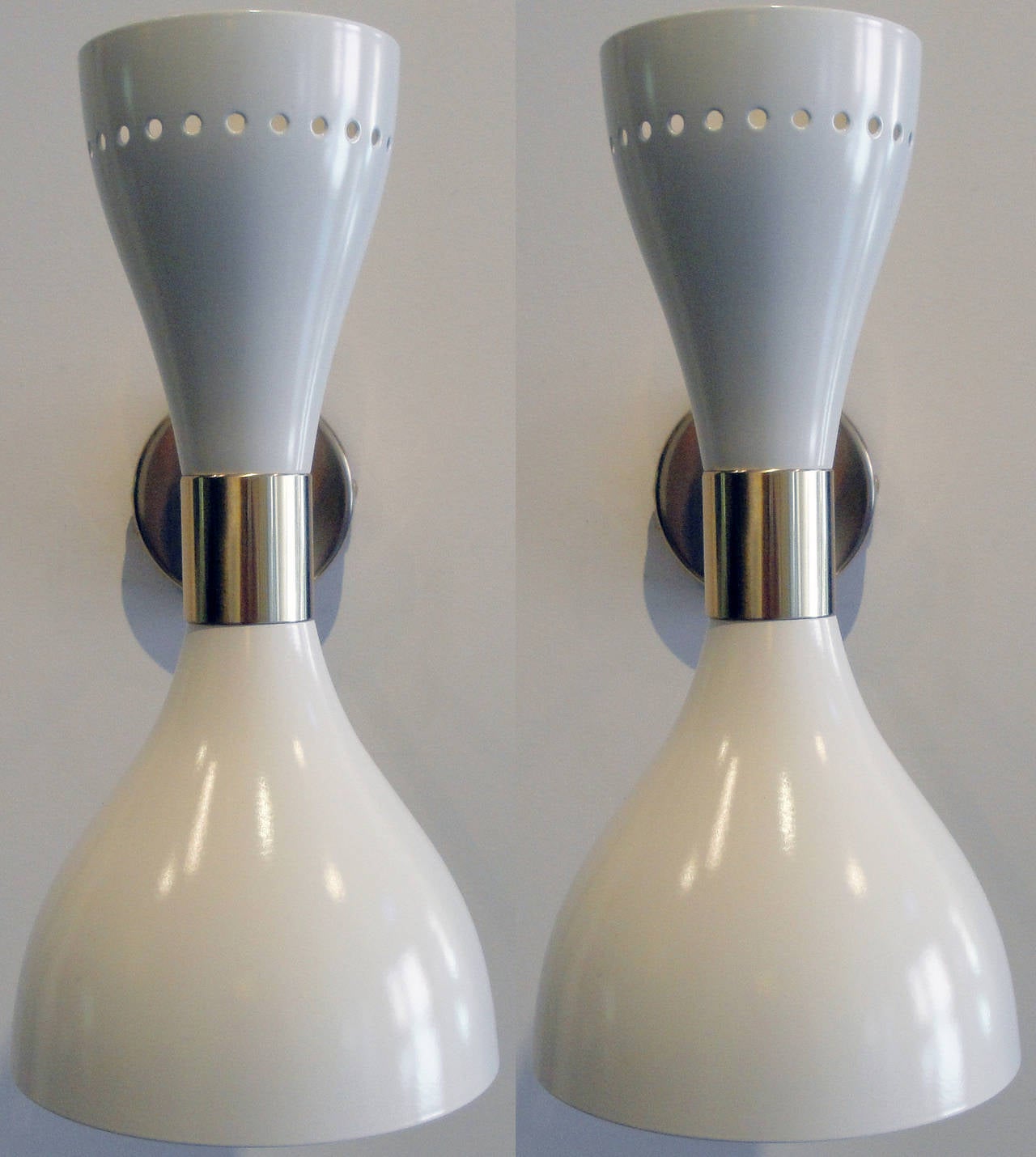White enamel on aluminum with brass arms and fittings.
Sconces can be positioned at any angle. Each sconce takes two bulbs, one at the bottom, one at the top. Brass arms, fully restored shades.