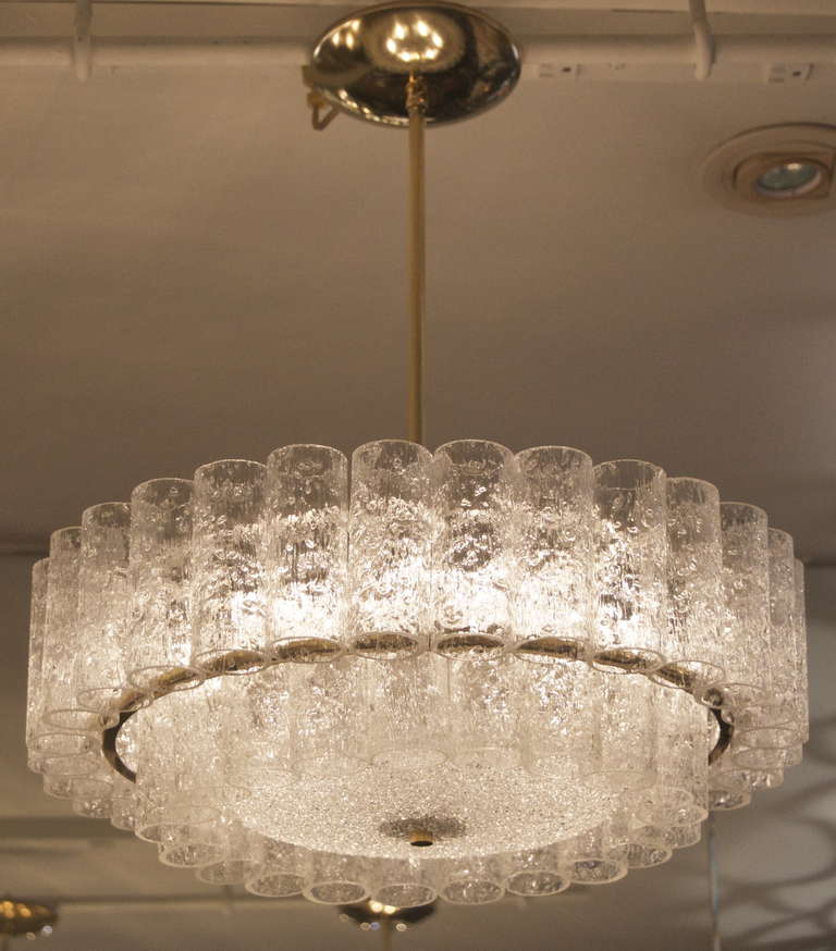 Elegant Doria two tier chandelier of organic ice glass tubes, the tiers separated by a narrow brass surround. A central glass diffuser provides even and gentle light.

Takes 6 E-14 base bulbs up to 40 watts per bulb, new wiring.

Height listed
