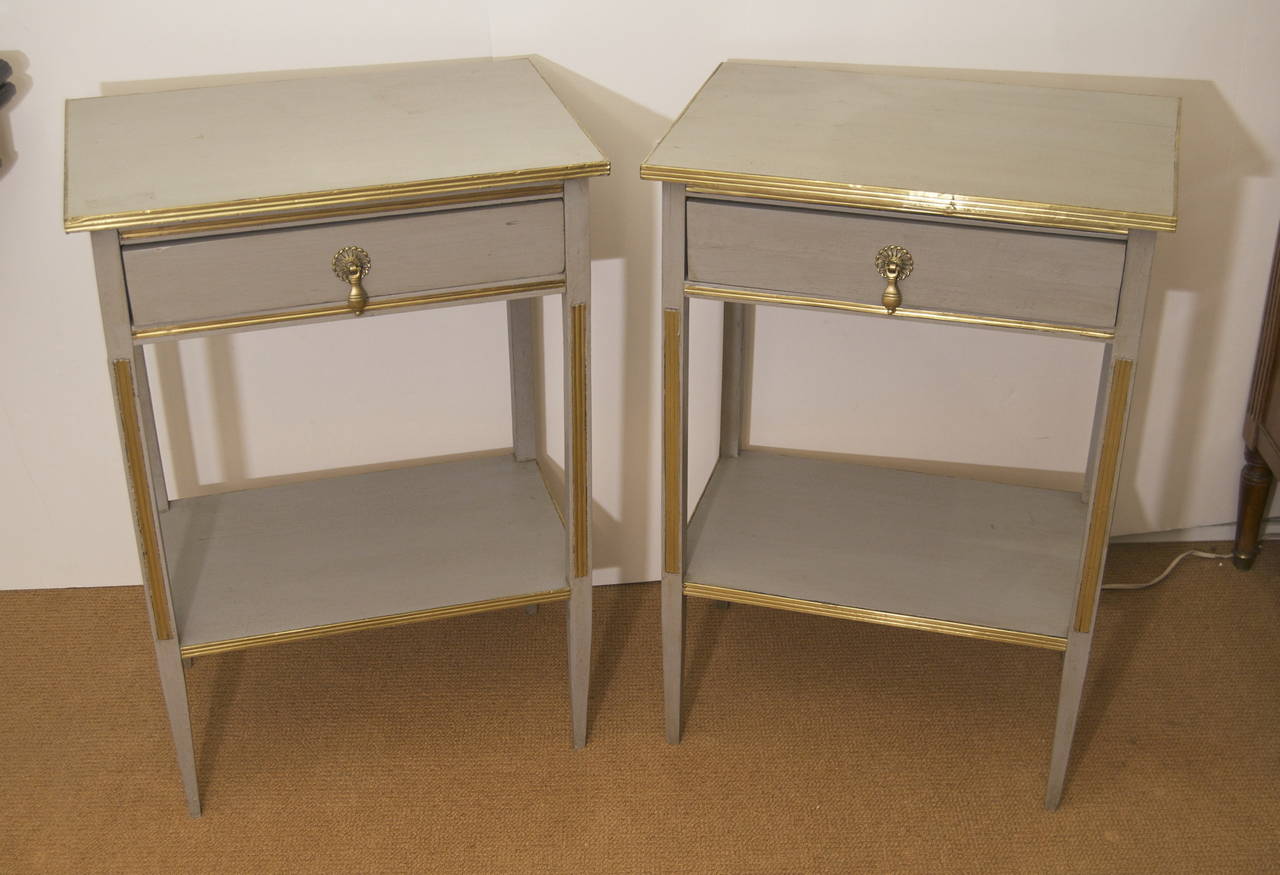 Pair of grey hand-painted nightstands with brass and gold leaf detail. These elegant nightstands will make a wonderful addition to all decors. Can also be used as end tables.