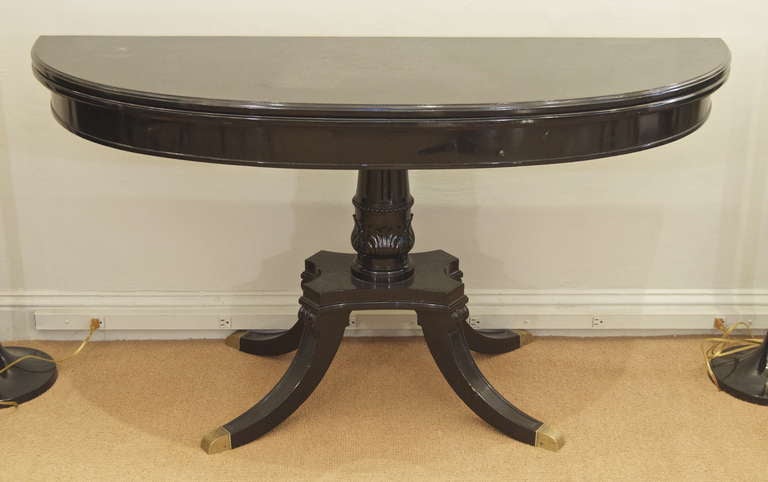 An excellent black lacquered Jansen flip top dining table, functional as a dining table, sideboard, or console, the lower legs ending in substantial brass feet. Central column showing classical acanthus forms at base.

Depth dimension listed is
