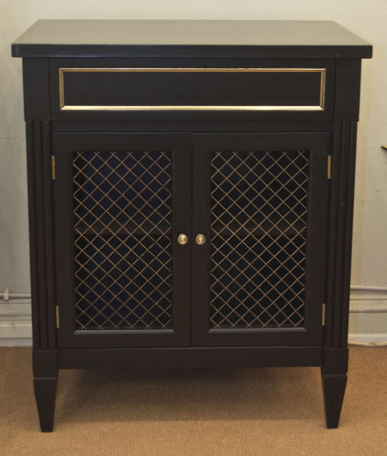 Simple, elegant black lacquer side table or cabinet. Well suited as a night stand.

Storage behind two open latticework doors and top drawer.