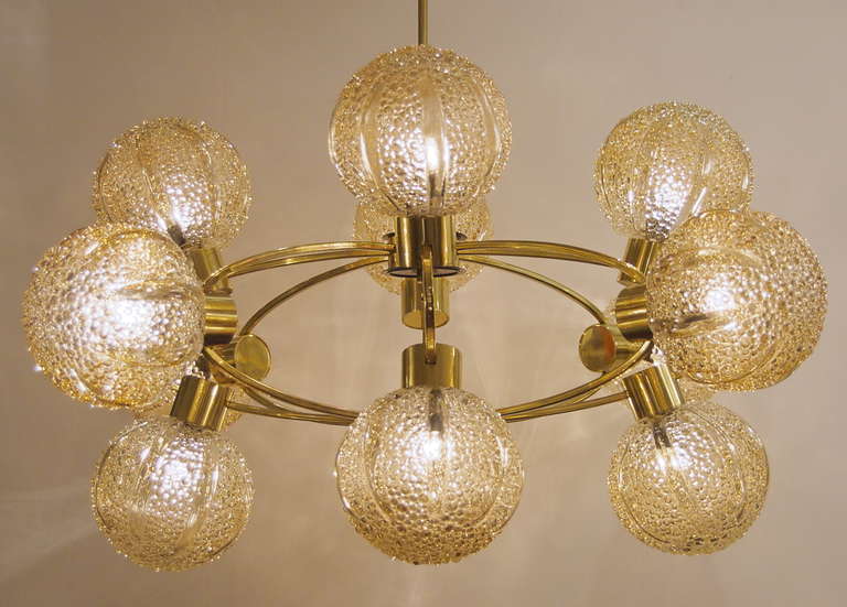 This unusually large chandelier features 12 amber tone glass globes with an organic pattern on an oval orbit brass fixture body.

Each globe takes a single E-14 base bulb up to 40 watts each, new wiring. Pictured lit with 12 watt bulbs.

Height
