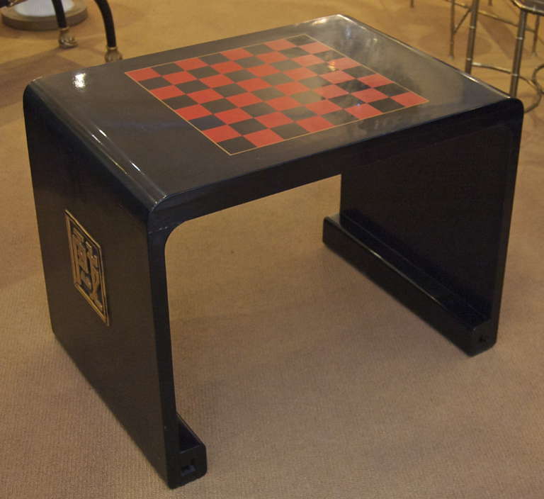 Elegant Chinoiserie French game table in black lacquer, with gilt detailing and a checkerboard pattern on the top.

Signed 1937.