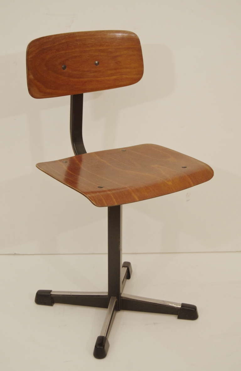 Charming child's desk chair, in a modern or Industrial form. Bent plywood seat and back on a black enameled frame, with aluminum trim and rubber capping on legs. Children's furniture.