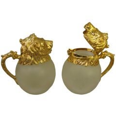 Pair of Polished Brass and Frosted Glass Lion's Head Pitchers