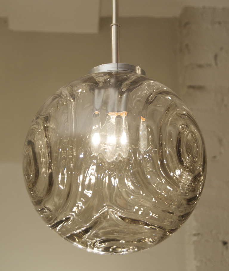 Fantastic globe pendant with light smoke tones; glass pattern resembles intersecting wave patterns. Optically interesting and a great look for a wide variety of styles and interiors.

Takes a single medium base bulb up to 75 watts. New wiring. Rod