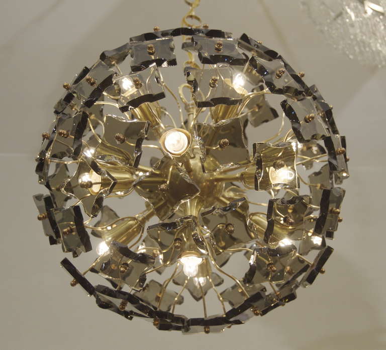 An unusual earlier Italian Sputnik form chandelier, curved support arms radiating from the sockets to support faceted smoked glass pieces. 76 total glass pieces.

Takes 13 E-14 base bulbs up to 40 watts per bulb, new wiring. Height listed is as