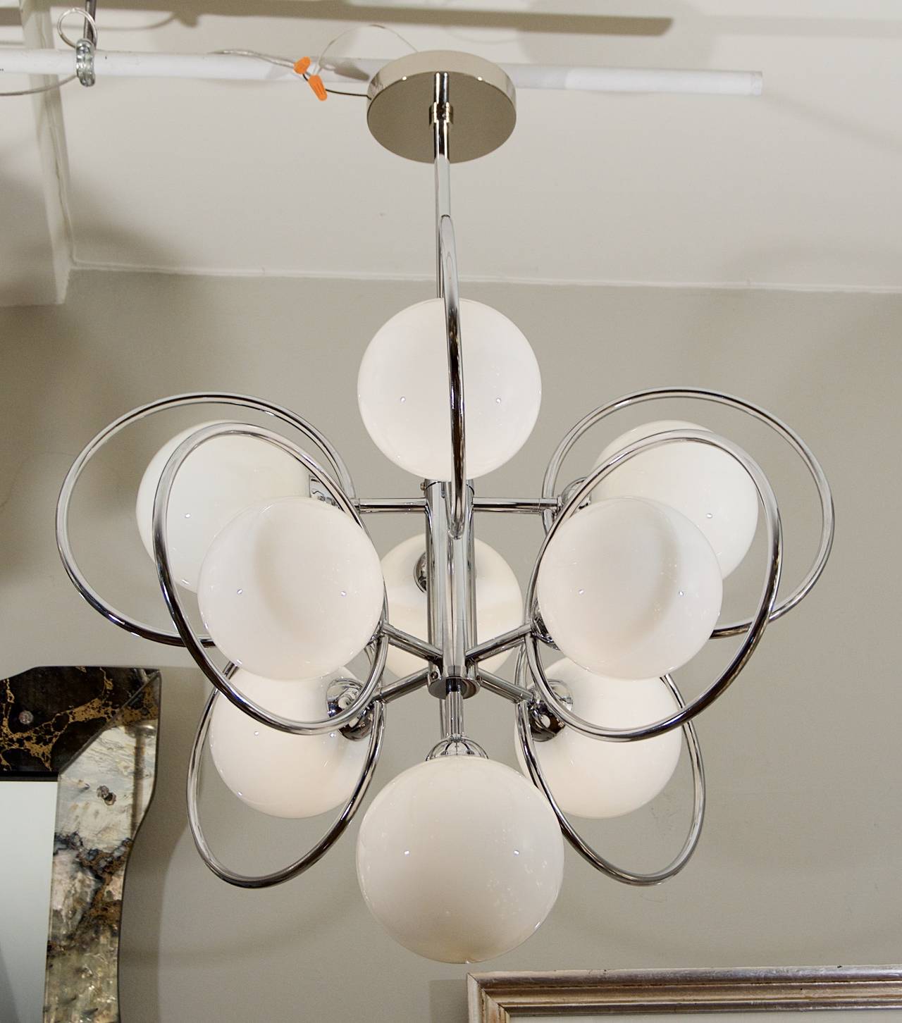 Elegant with an edge. A wonderful addition to all decors. White glossy finish globes and polished chrome make this a stand out piece.

Eight E-14 base bulbs up to 40 watts per socket, new wiring.

Height is of chandelier body only; height as