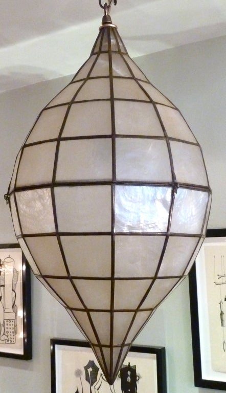 This great example of mid-century style will cast beautiful warm light in your space through it's capiz and brass surface. hanging on an adjustable length chain.  One socket up to 100 watts.