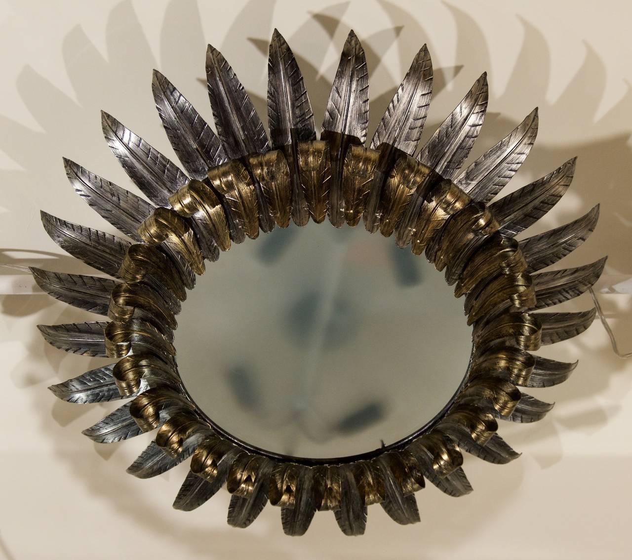 A unusual and attractive ceiling fixture with double-tiered leaves forming a sunburst pattern. The upper leaves have a soft silvered metal finish while the lower leaves have gold accents.

Makes a unique and elegant addition for all