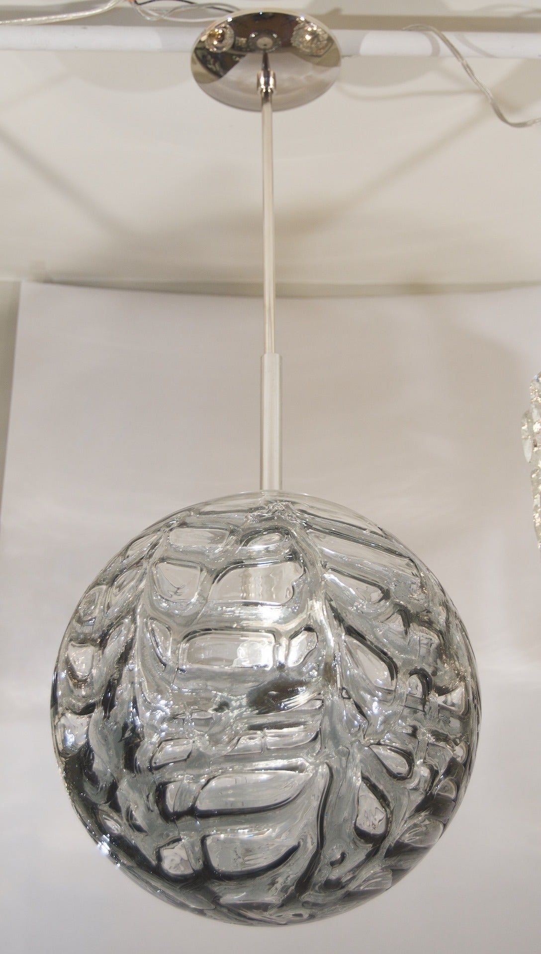 Elegant Doria pendant. Organic patterned smoke toned glass with chrome body complements all decors. 

Takes a single medium base bulb up to 100 watts, new wiring.
Length of drop rod can be adjusted.

See other listings for other sizes and tones