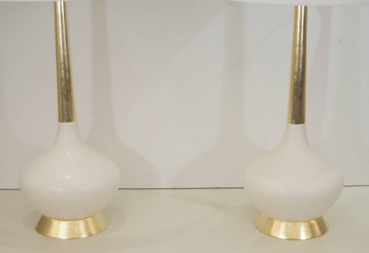 Excellently formed off-white ceramic table lamps with giltwood base and stem. 

New wiring and three-way sockets, up to 150 watts. Height listed is with 10