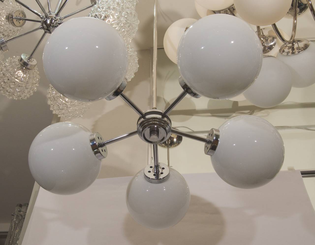 A radial chrome five armed chandelier with opal glass globes. 

Takes five E-14 base bulbs up to 40 watts per bulb. New wiring.

Height is of chandelier body height is hung is 39