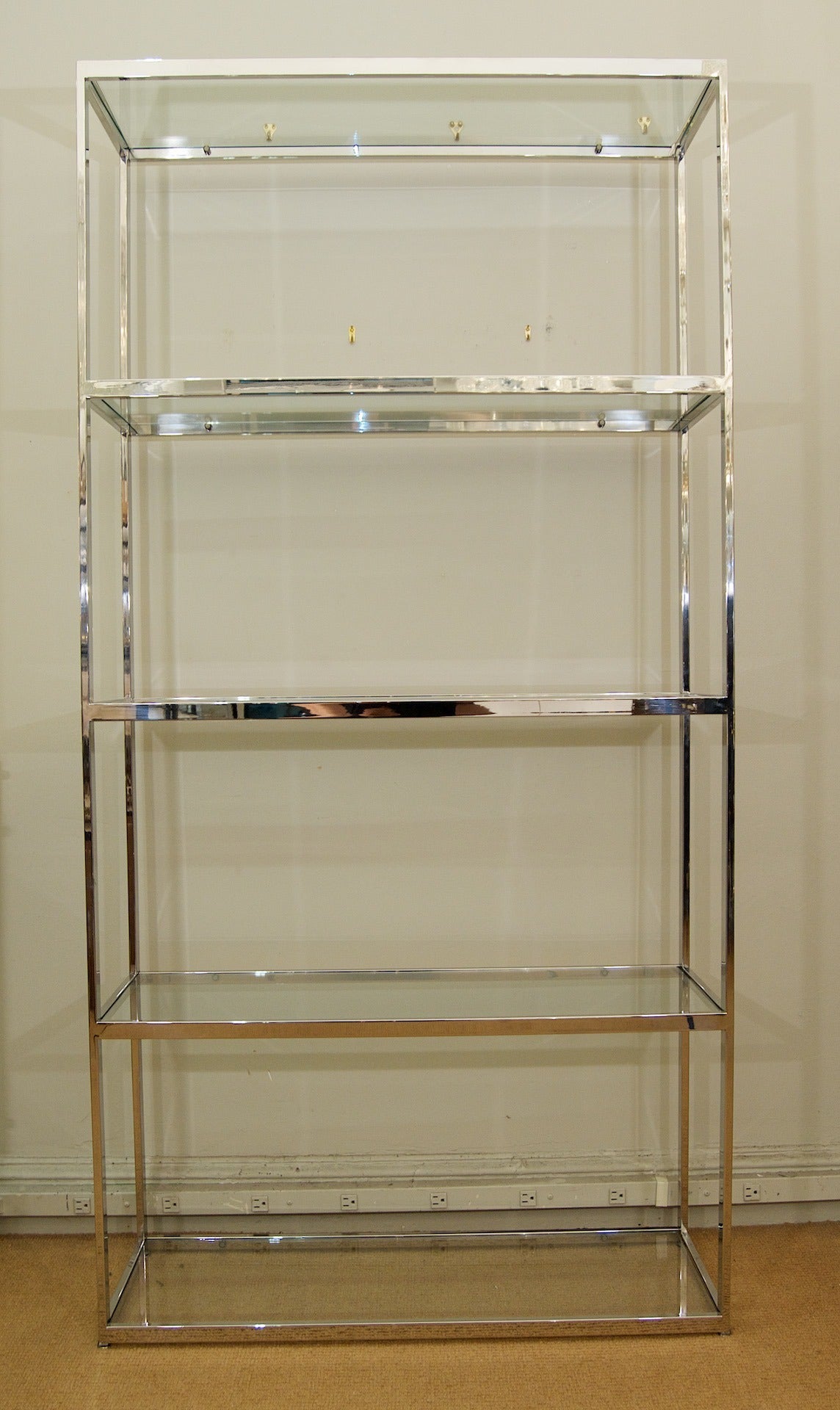 A five-glass shelved chrome etagere in the style of Milo Baughman boasts clean linear lines.