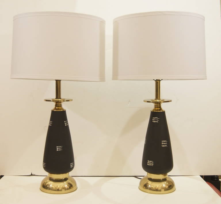 Unusual pair of brass and enameled metal mid century table lamps, with an elegant white wave pattern on the black enameled centers. Well proportioned and a unique design.

Height listed is with 9