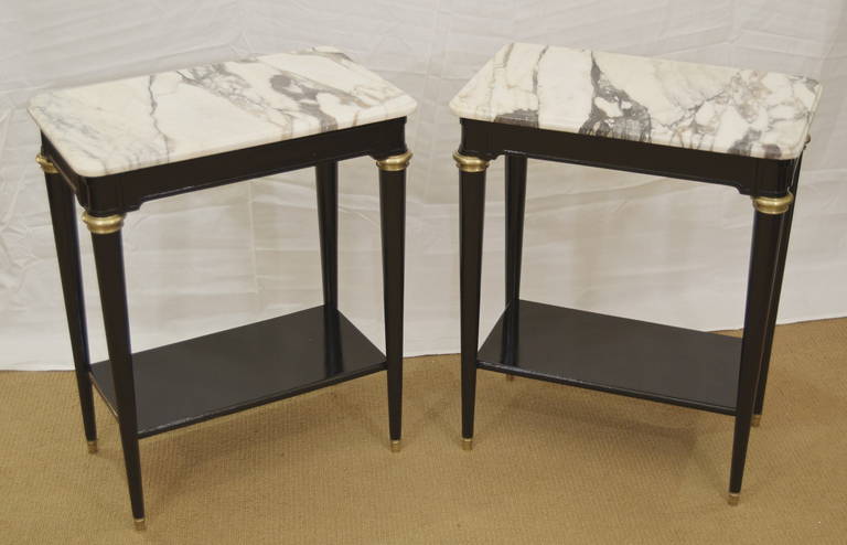 A good pair of Directoire style side tables having molded edge marble tops over shaped apron and lower tier shelf. Beautiful elegant tables with marble tops.
A wonderful addition to all decors.