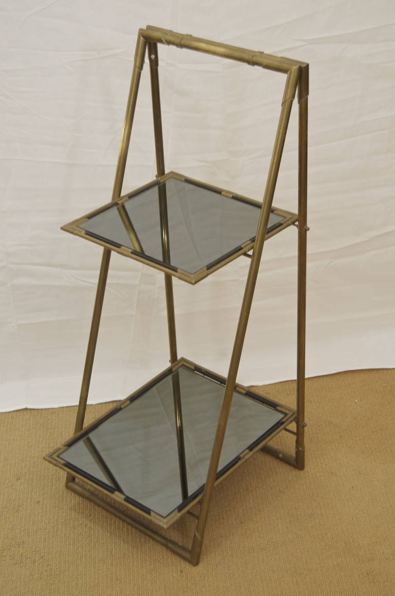 A two-tier bronze folding Italian end table or plant Stand having black mirrored glass inserts.