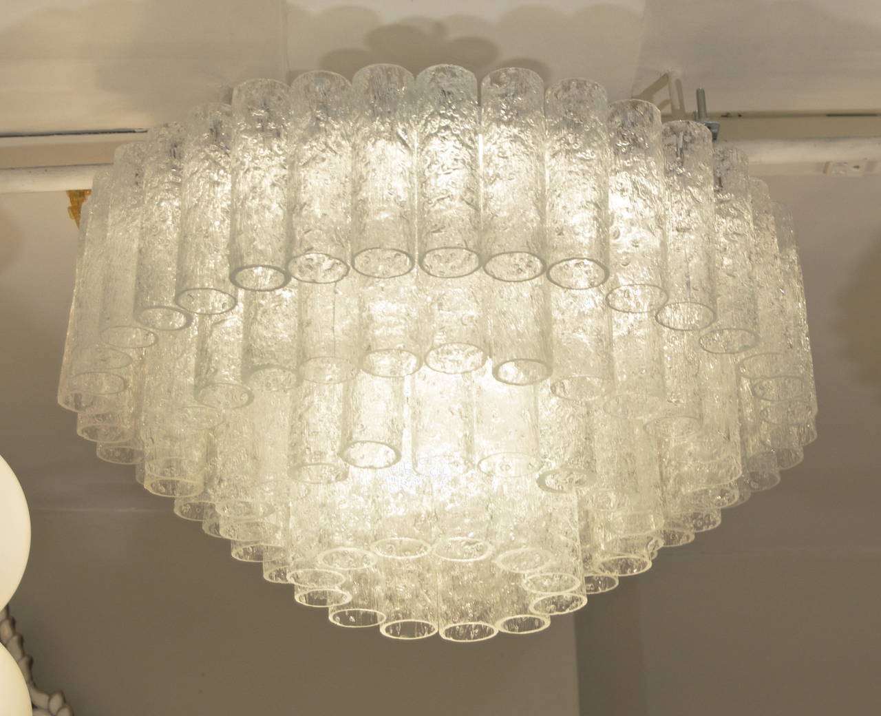 This exceptional flush mount chandelier by Doria has four tiers bearing 96 separate tubes of glass.

Takes ten E-14 bulbs, six radiating at the top-tier, with four down lighting at center of chandelier. Each up to 40W each, new wiring.