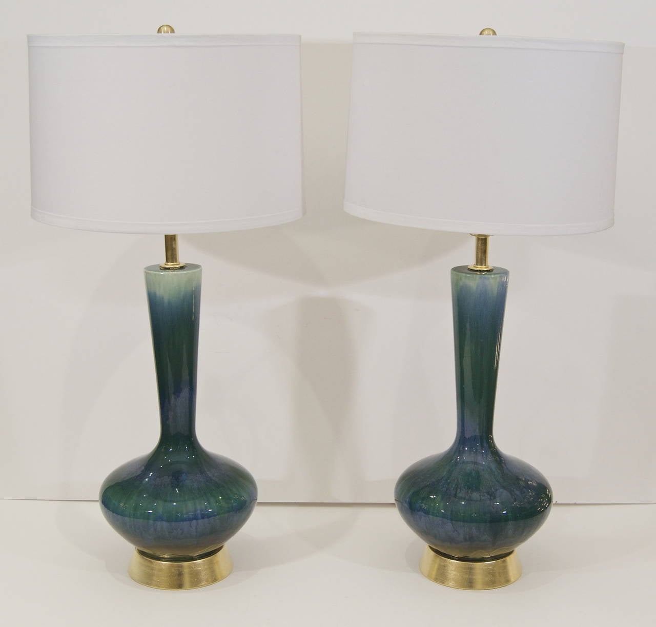 Excellent pair of table lamps similar in style to Royal Haeger, the dramatically proportioned body surmounting a hand gilt base.

Three way socket up to 150 watts, new wiring and socket.

Lampshades shown are for demonstration purposes only and