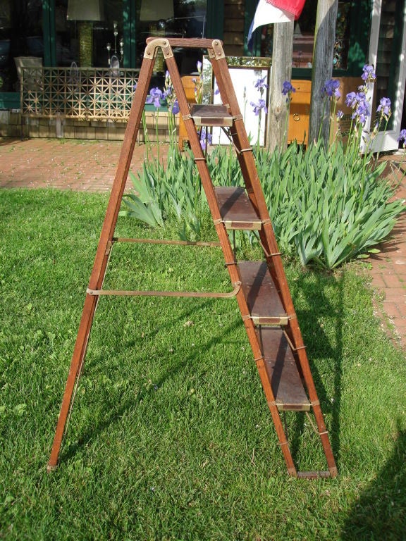Mahogany four step library ladder with metal accents,collapsible steps support for compact storage.