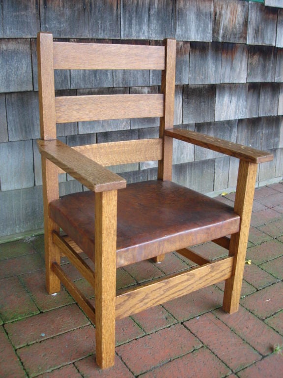 A great example of the mission/arts & crafts period, this child's armchair with original leather, nail head finish and makers stamp on rear and underside.