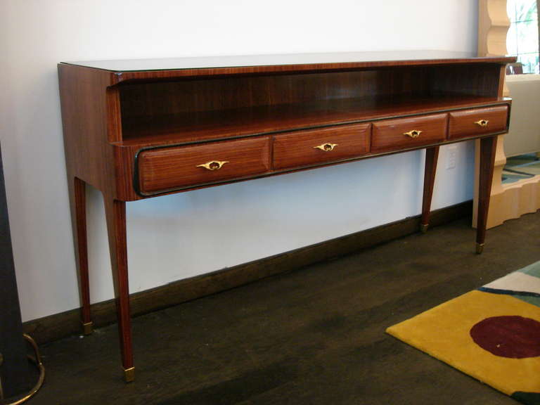 Four beautiful drawers for dining room items, cutlery, etc. Sexy legs with brass sabots and black glass top on fruitwood veneer.