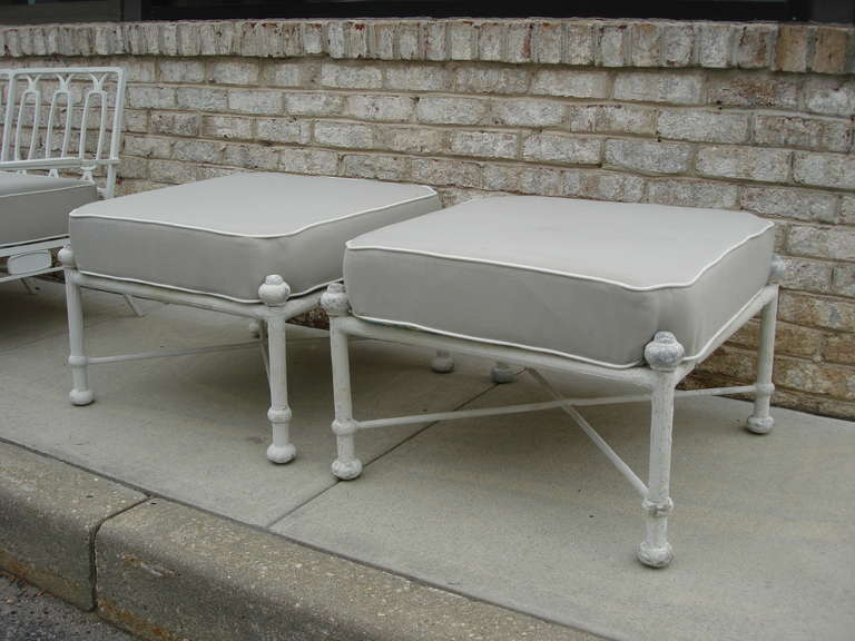 Covered in sunbrella sturdy fabric, these matching ottomans with ball finials and X-stretcher base are in original distressed plaster condition. Excellent for indoors or outdoors.