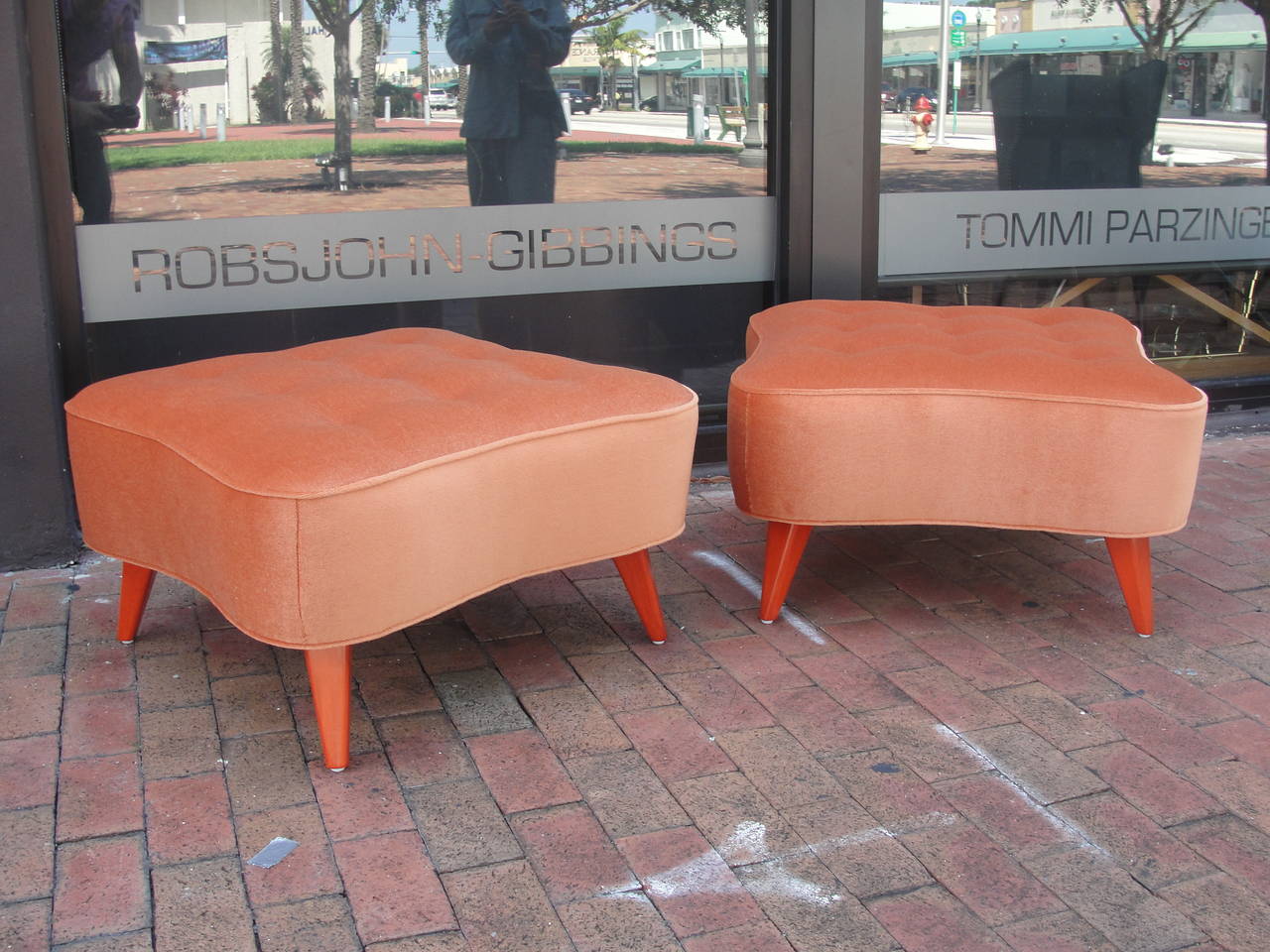 Oversized and heavy in quality, these 1940s ottomans have been carefully restored in lush orange velvet and matching orange lacquered flared feet, possibly designed by Billy Haines. Can be sold individually - priced as a pair.