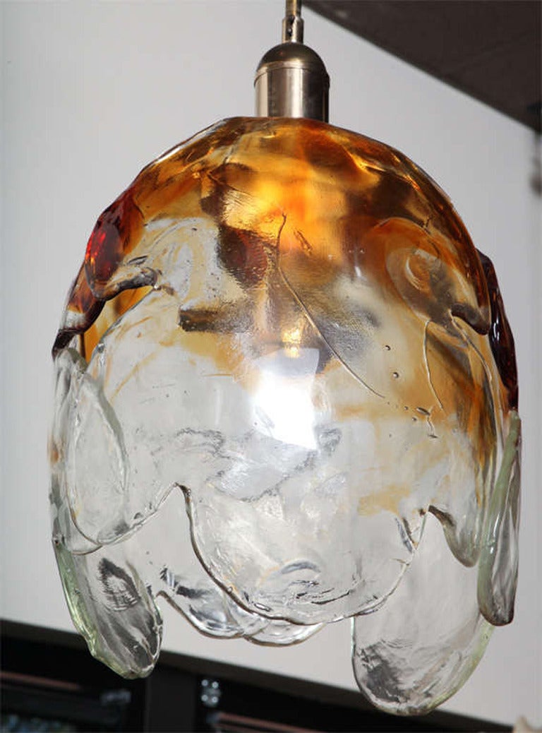 In three large handblown pieces of clear and amber glass, this upside down large tulip light fixture gives great light and beauty to any space by Carlo Nason.