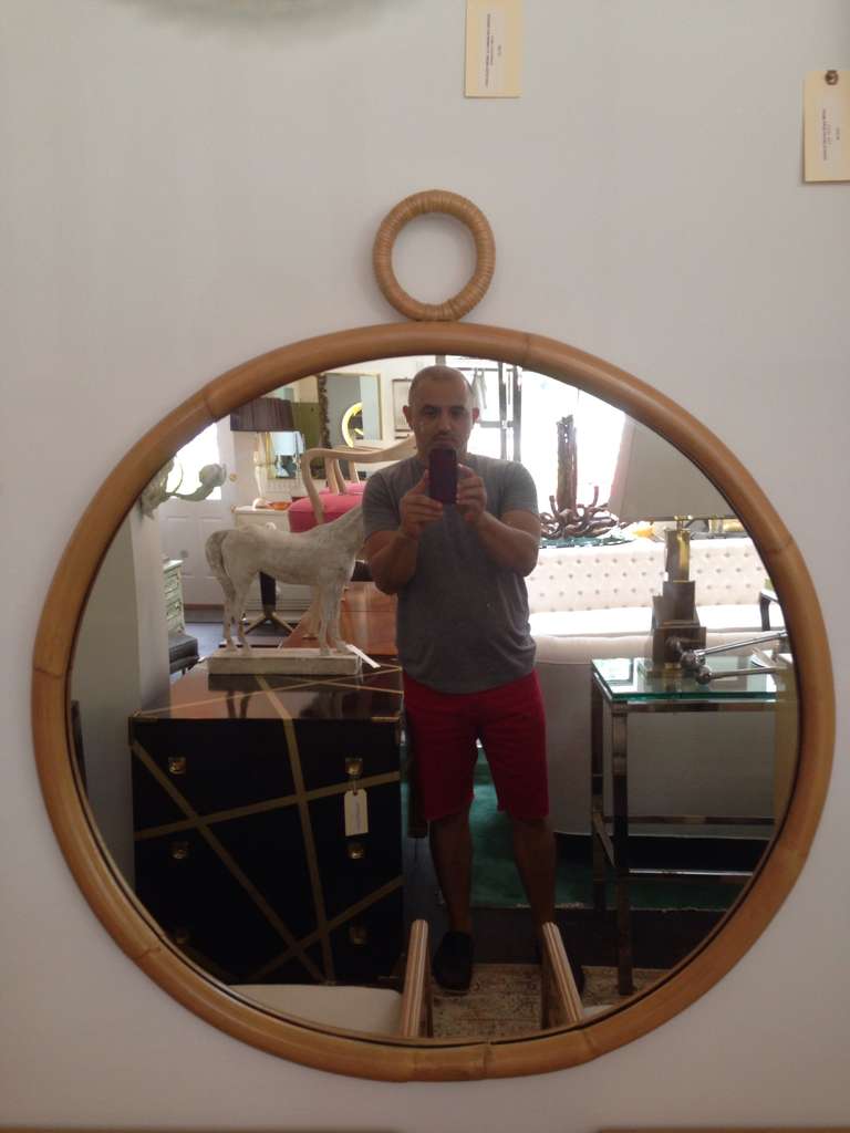 Round bamboo mirror with decorative circular woven bamboo accent at top.