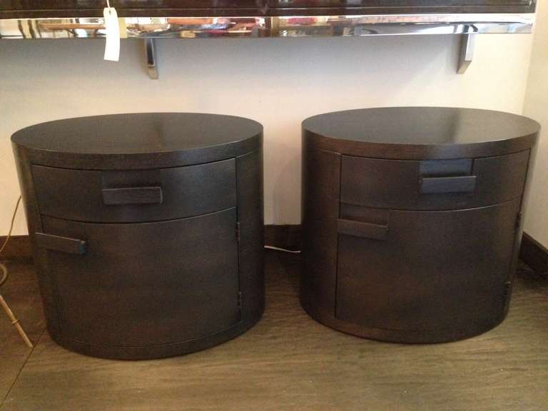 Rare oval nightstands or end tables each with one drawer and one hinged cabinet drawer.