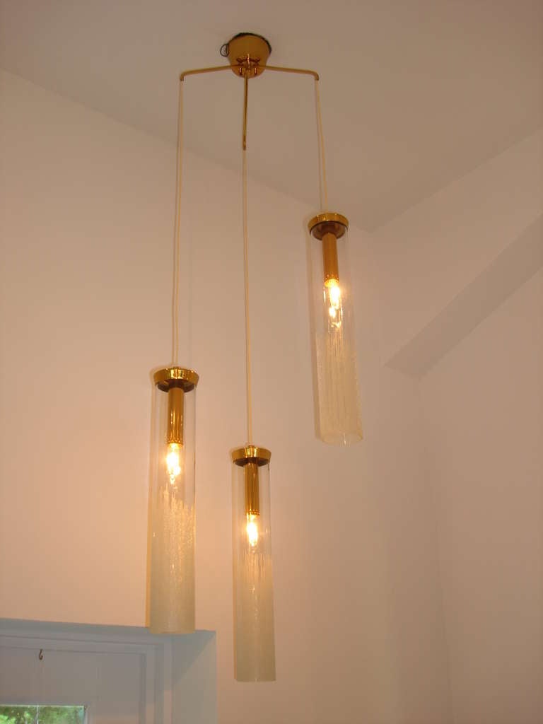 Each glass diffuser has gradiated frost effect and three lights, brass canopy and arms.