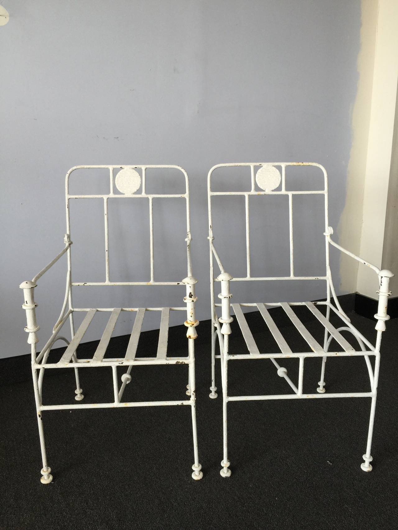 Matching pair of wrought iron chairs with paint finish in as found condition. 