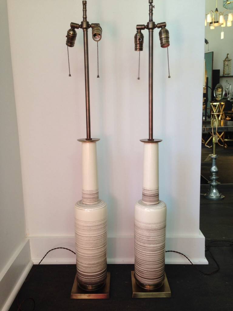 Pair of Mid-Century Modern glazed ceramic bottle vase form lamps on bronze bases, in bone with grey striations and subtle craqueleur to glazing. Double cluster sockets and silk rewiring recently done.