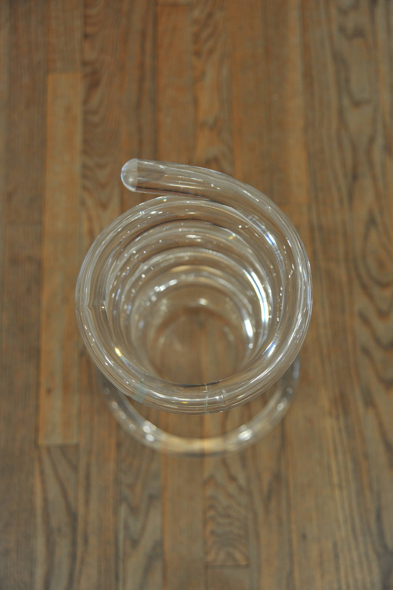 Lucite umbrella stand by Dorothy Thorpe with its original lucite container. The twisted lucite tubing is an innovative use of material for a modern umbrella stand. The umbrella stand also transcends its function and can be viewed as a sculpture.