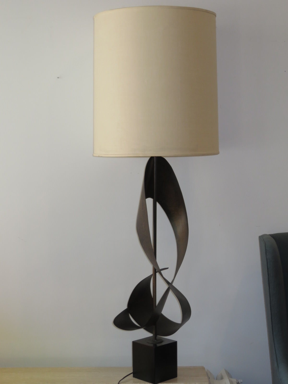 The sculptural patinated steel table lamp by Harry Balmer measures 30