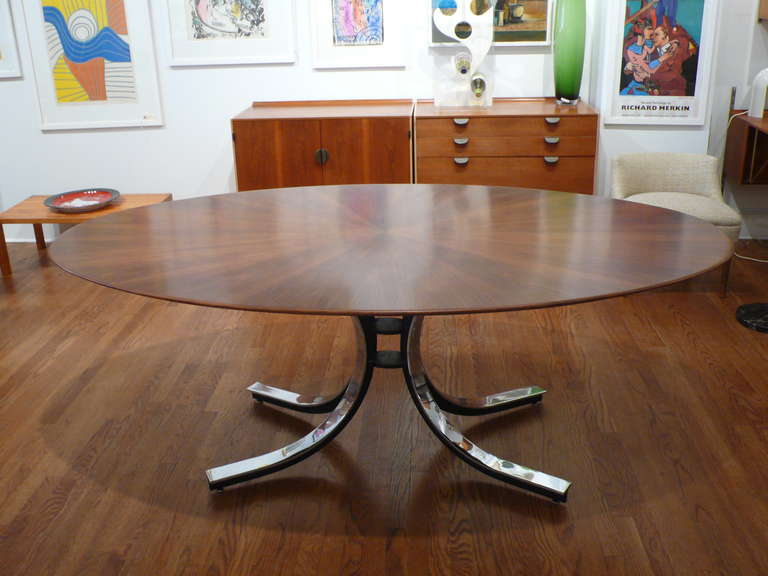 Oval dining or conference table designed by Osvalso Borsani for Stow Davis made from book matched walnut, forming a sun burst pattern on a curved steel base. The top has a fine knife edged bevel. Beautifully crafted.