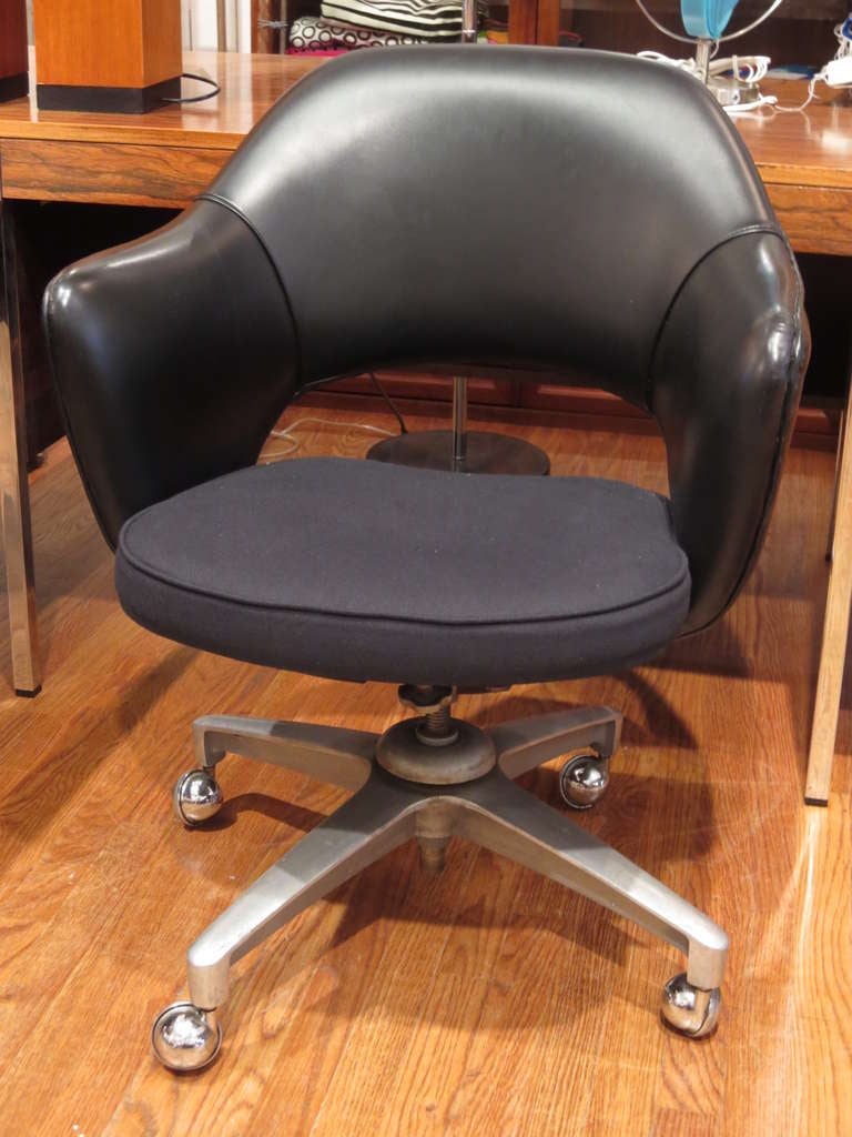 This chair has its original back in vinyl, the seat has been reupholstered; it swivels and tilts on four steel points base on steel casters .