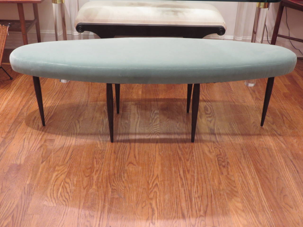 Long oval shaped bench, recently reupholstered in turquoise velvet; very delicate