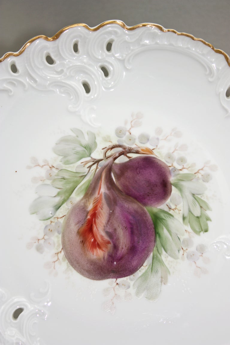This unusual set of ten Nymphenburg dessert or fruit plates are hand-painted with fruit specimens with the interesting addition of nuts, pomegranates and gooseberries. The ground is a clean white, creating a dramatic contrast to the polychrome