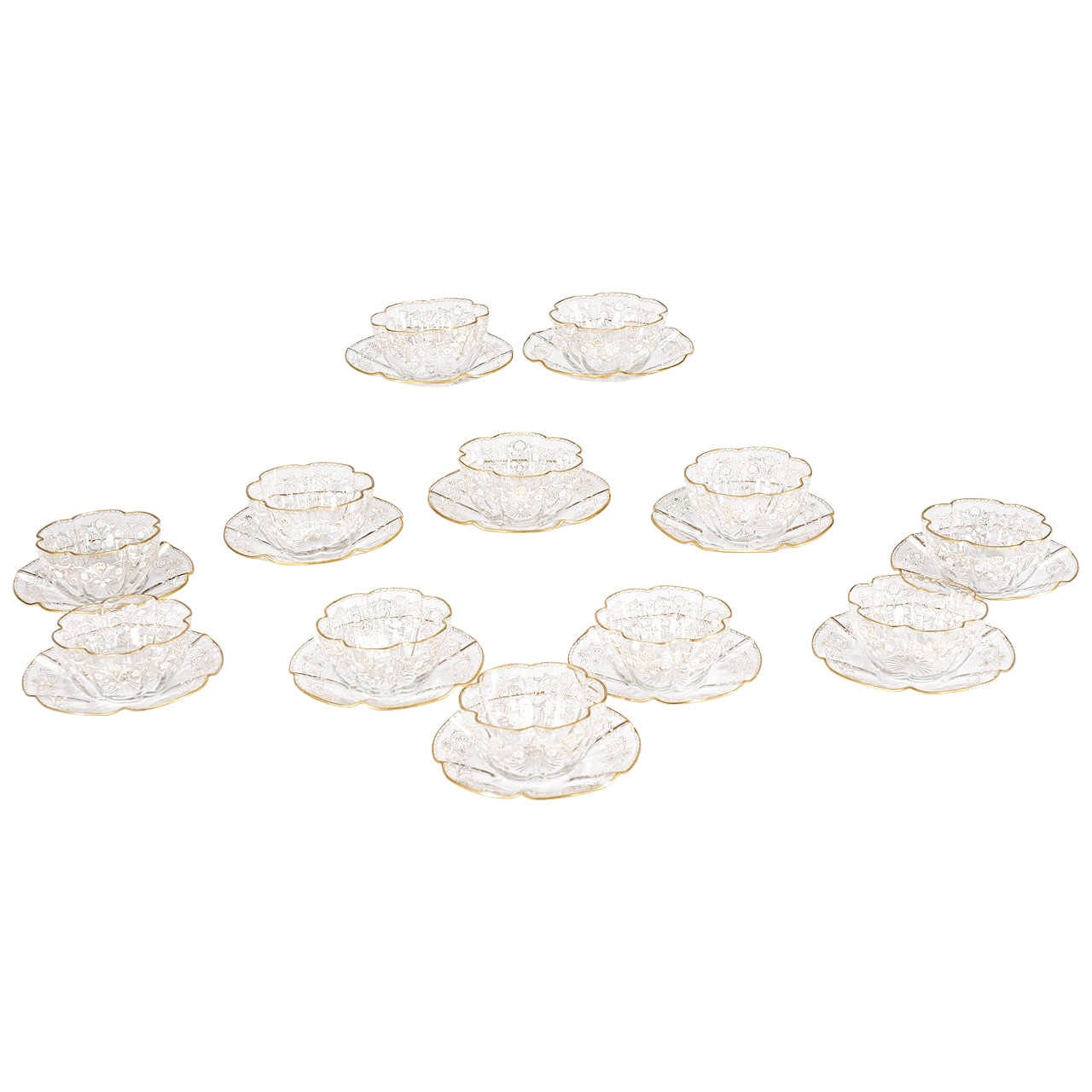 A perfect set of 12 Moser handblown crystal bowls and matching under plates in a graceful quatrefoil shape and star-cut base. Embellished with hand-painted white enamel and highlighted with gold leaf, these bowls are the elegant start to a lovely