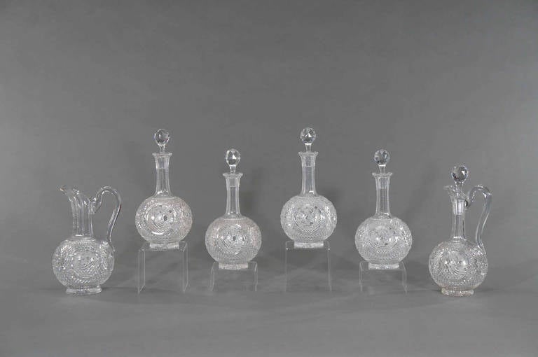 This is a rare and exceptional 19th century crystal drinks set attributed to Baccarat. The service consists of four matching decanters, a claret jug and a matching water pitcher. Each piece is handblown with diamond point cutting and star cut base.