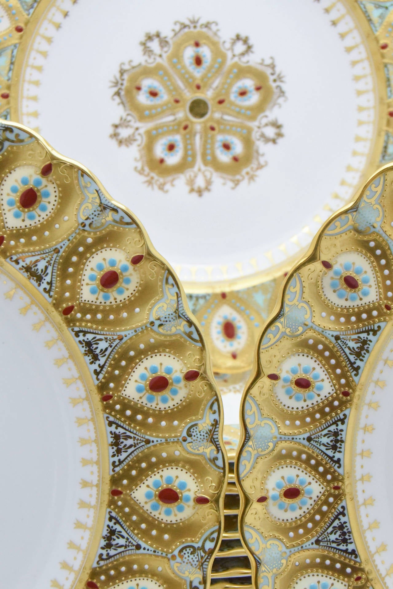This amazing set of 12 dinner plates, made by Copelands Spode, are fit for royalty. Each plate is decorated with one of the most elaborate and labor intensive methods of gold overlay and set with multicolored 