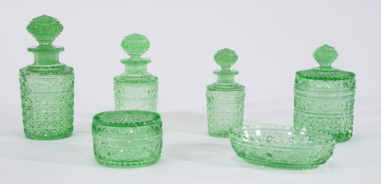This lovely 6 piece dresser set was made by Val Saint Lambert and includes the whole array of pieces for a dresser or vanity. The set includes 3 graduated perfume bottles, a soap dish and 2 covered boxes. It is made in molded crystal, a technique