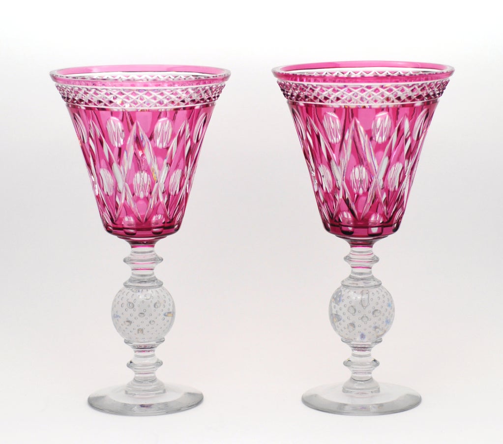 This is a lovely pair of Pairpoint hand blown crystal vases with cranberry overlay cut to clear. They are a well matched pair,  perfect for a mantle or sideboard with controlled bubble connectors and clear foot.